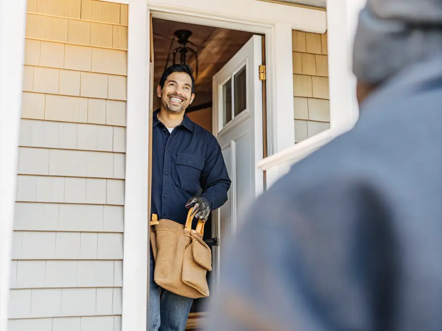 A Bayline electrician greeting a homeowner at the front door